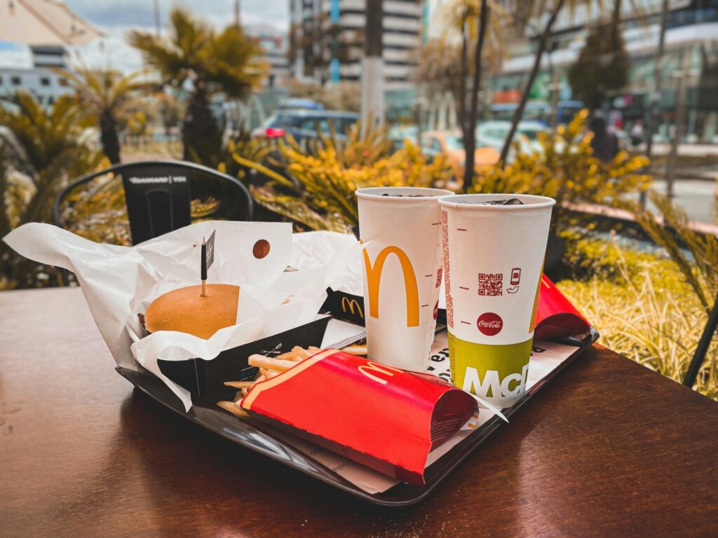 Zestaw fast food z burgerem, frytkami i napojami na stoliku w mieście